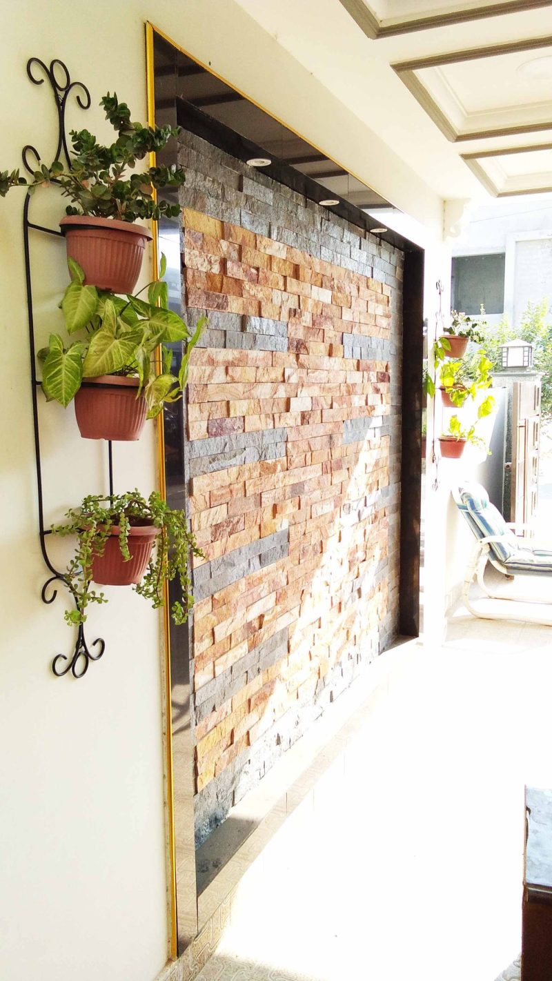 Courtyard planted with baskets, planters and metal stands