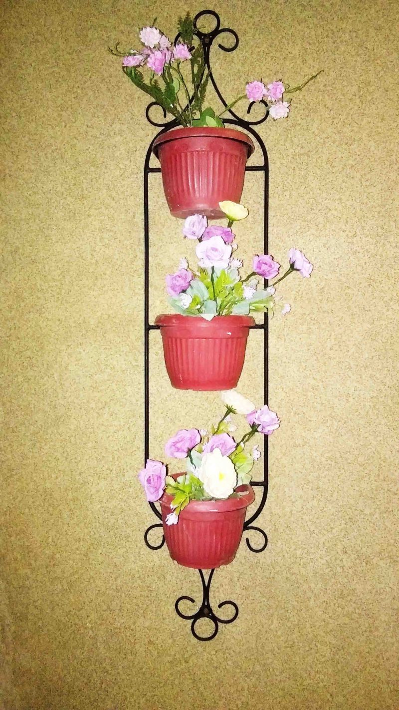 Boundary wall planted with tiered metal frames and coco-lined baskets